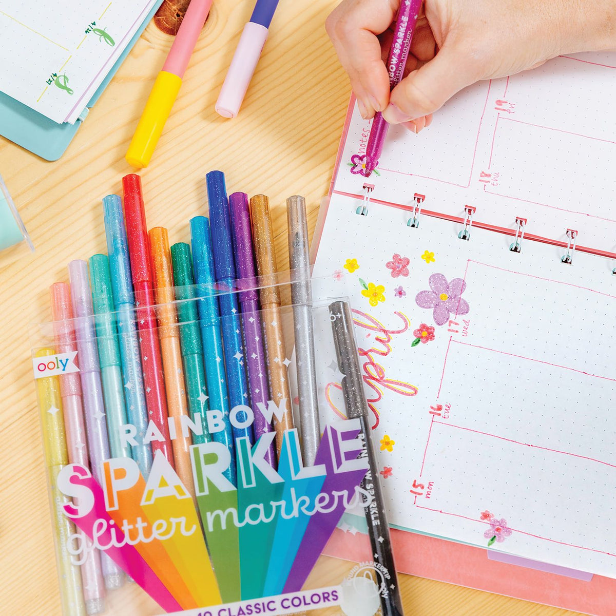 a girl drawing rainbow sparkle glitter markers in various colors,