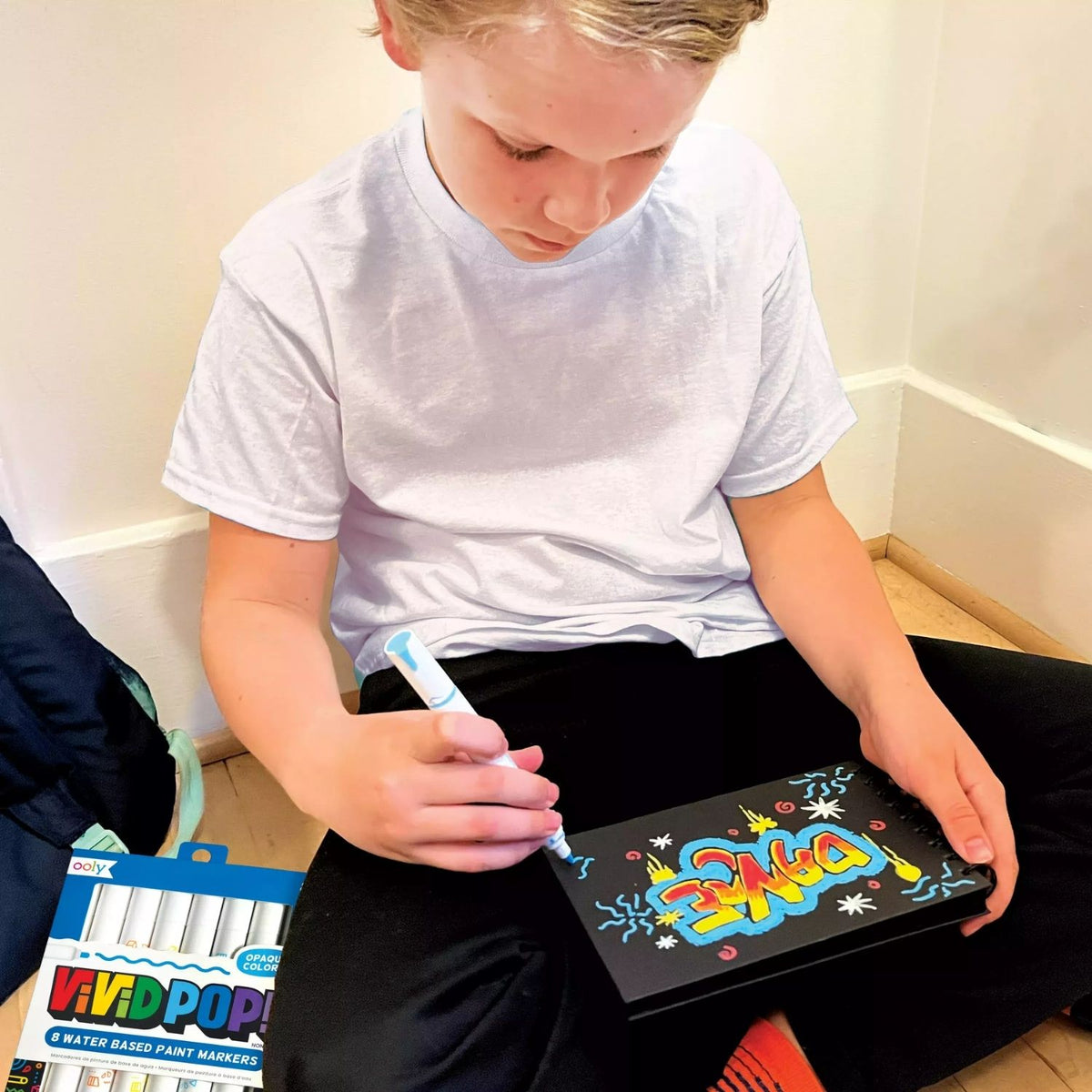 a boy drawing with Vivid Pop! Water Based Paint Markers Metallic, displaying 8 markers with metallic colors,