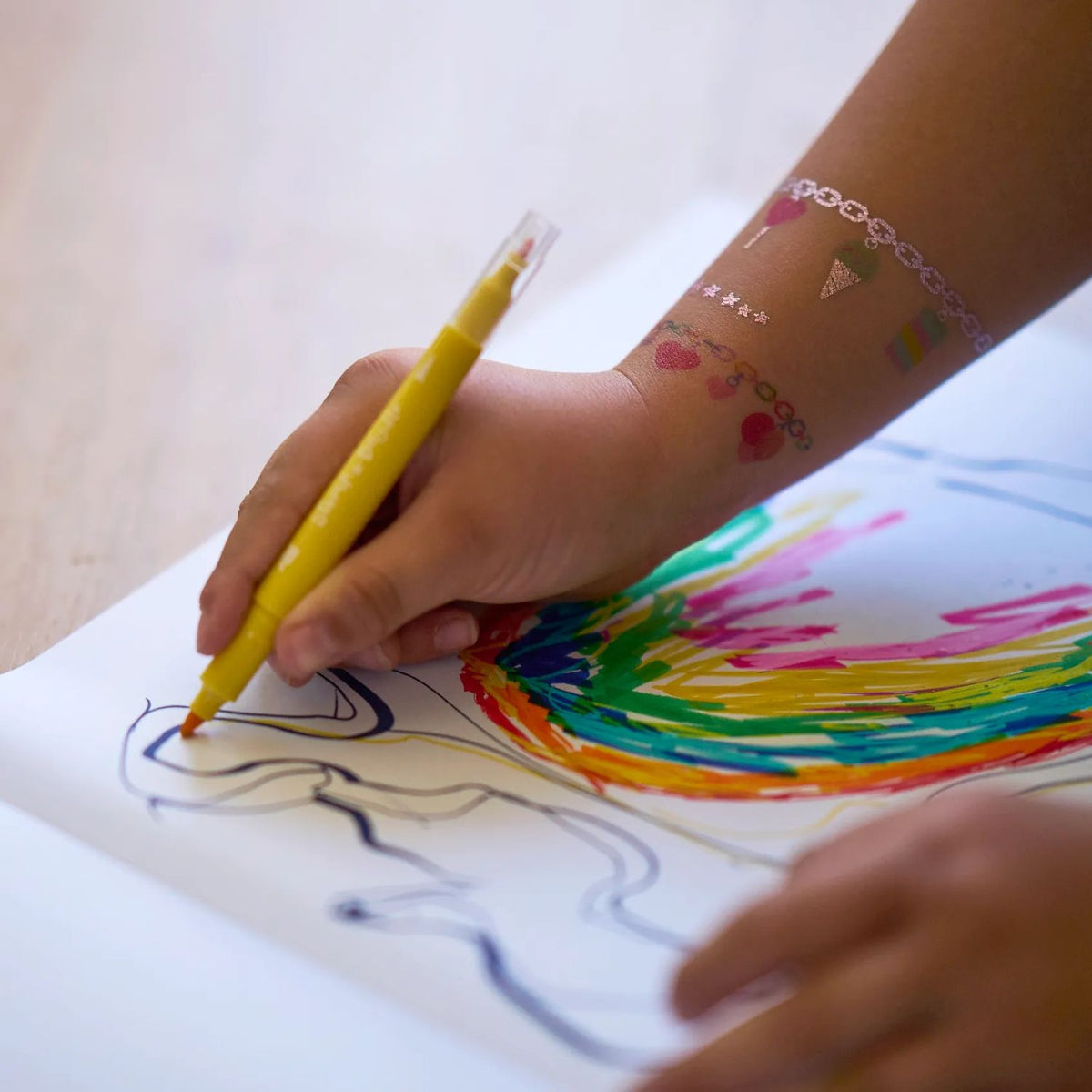 a girl drawing using the markers