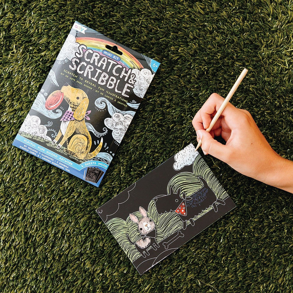 Packaging for a Mini Scratch &amp; Scribble Art Kit featuring playful puppies, including scratch cards and a wooden scratching tool.