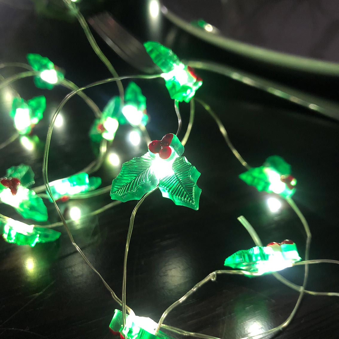 String lights with green fish-shaped bulbs on a dark background