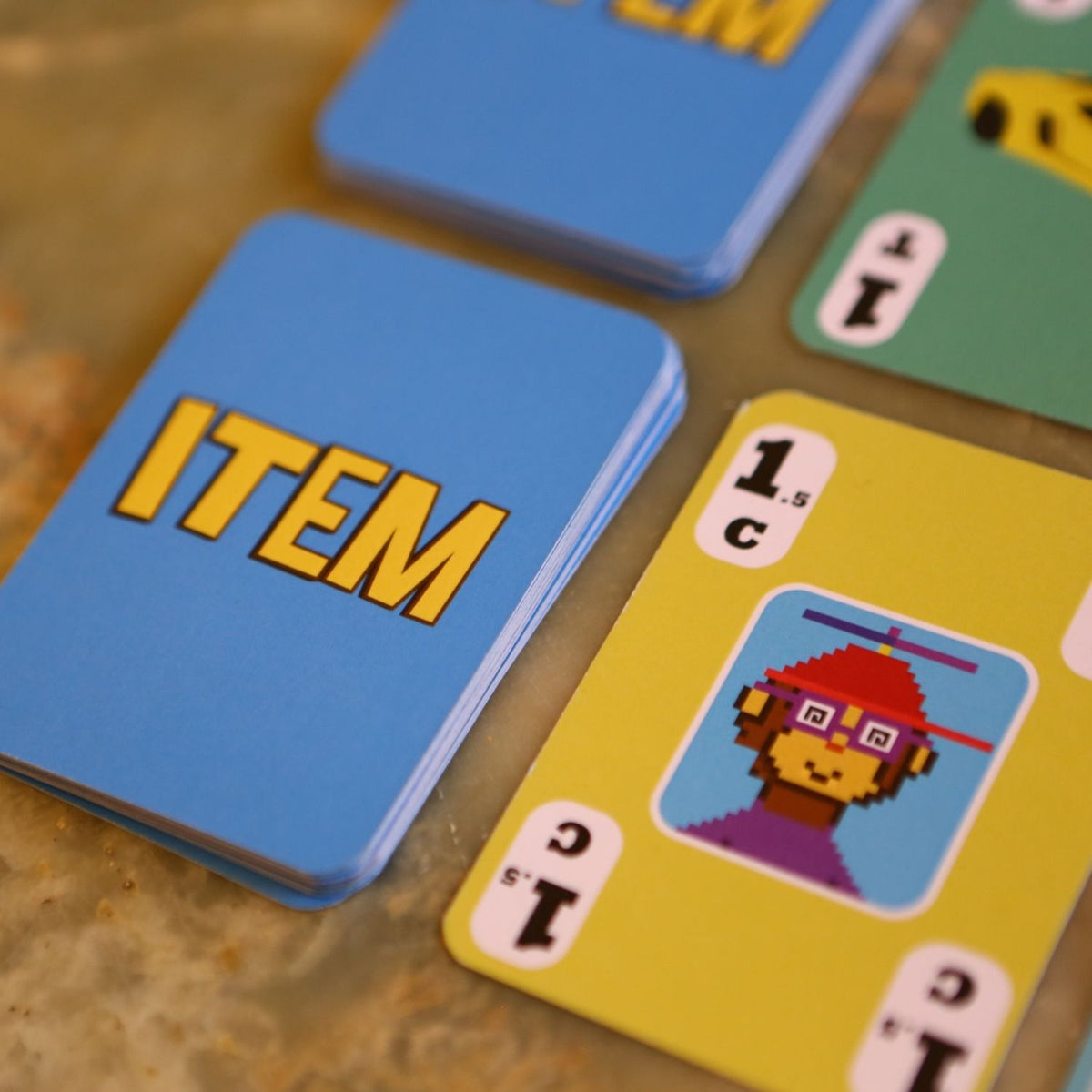 Close-up of playing cards with 'ITEM' text and a character illustration on a wooden surface.