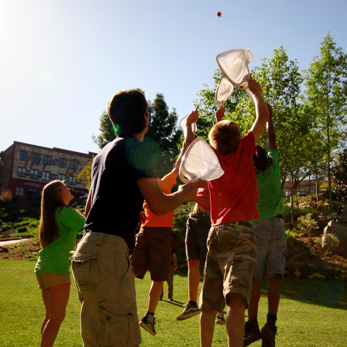 Group of people playing with SlingBall Classic on a grassy field