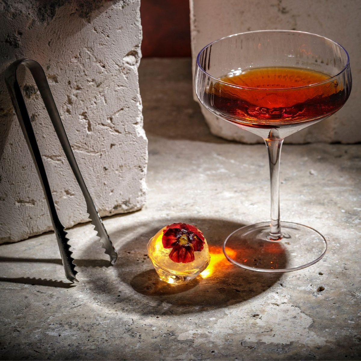 Flexible, food-grade silicone large round ice mould shown being popped open to reveal perfectly smooth spheres for cocktails and everyday drinks.