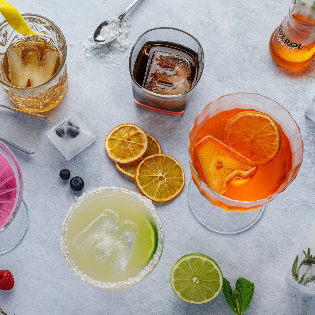 Assorted cocktails with DrinksPlinks letter ice cubes and garnishes