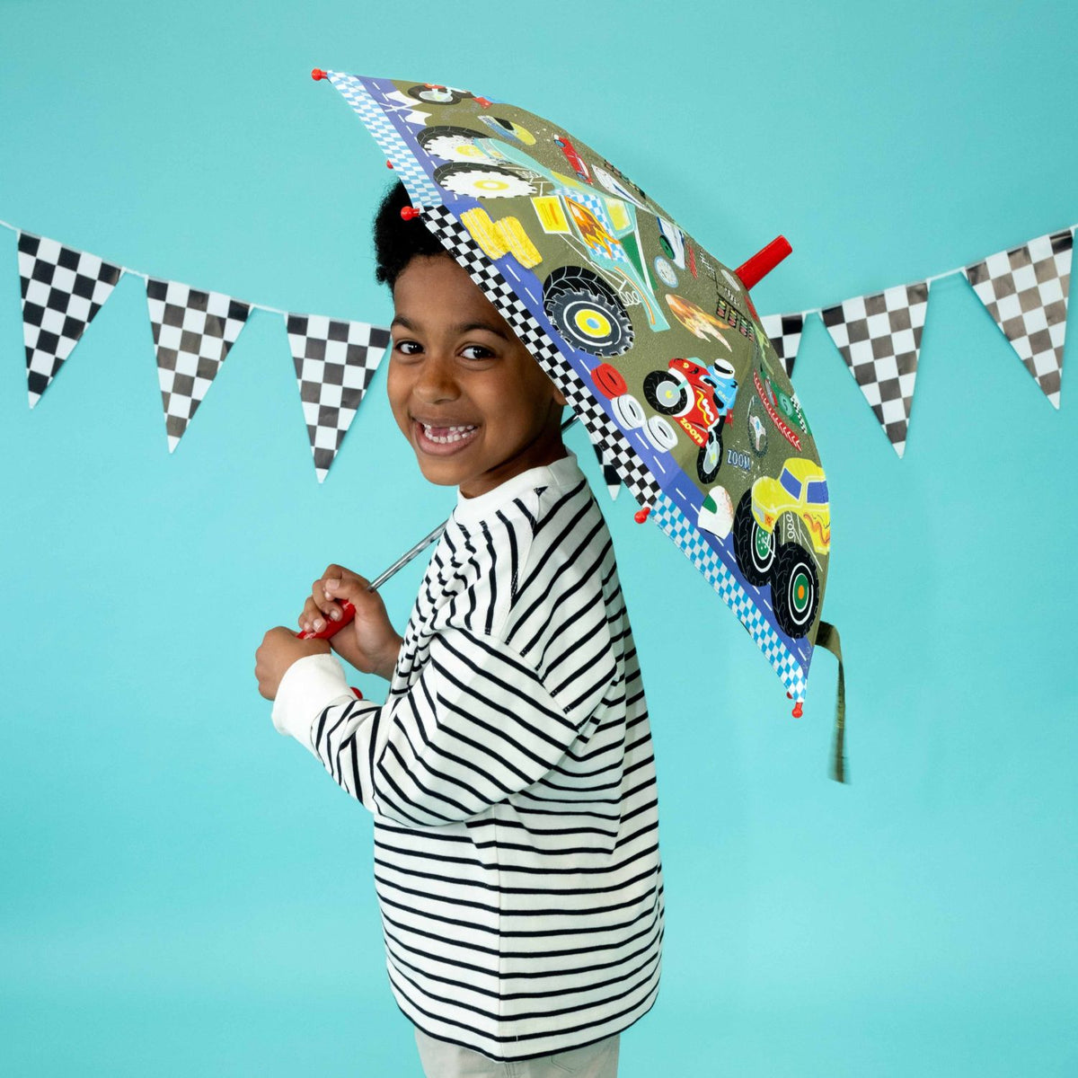 Child holding a colorful umbrella with car design