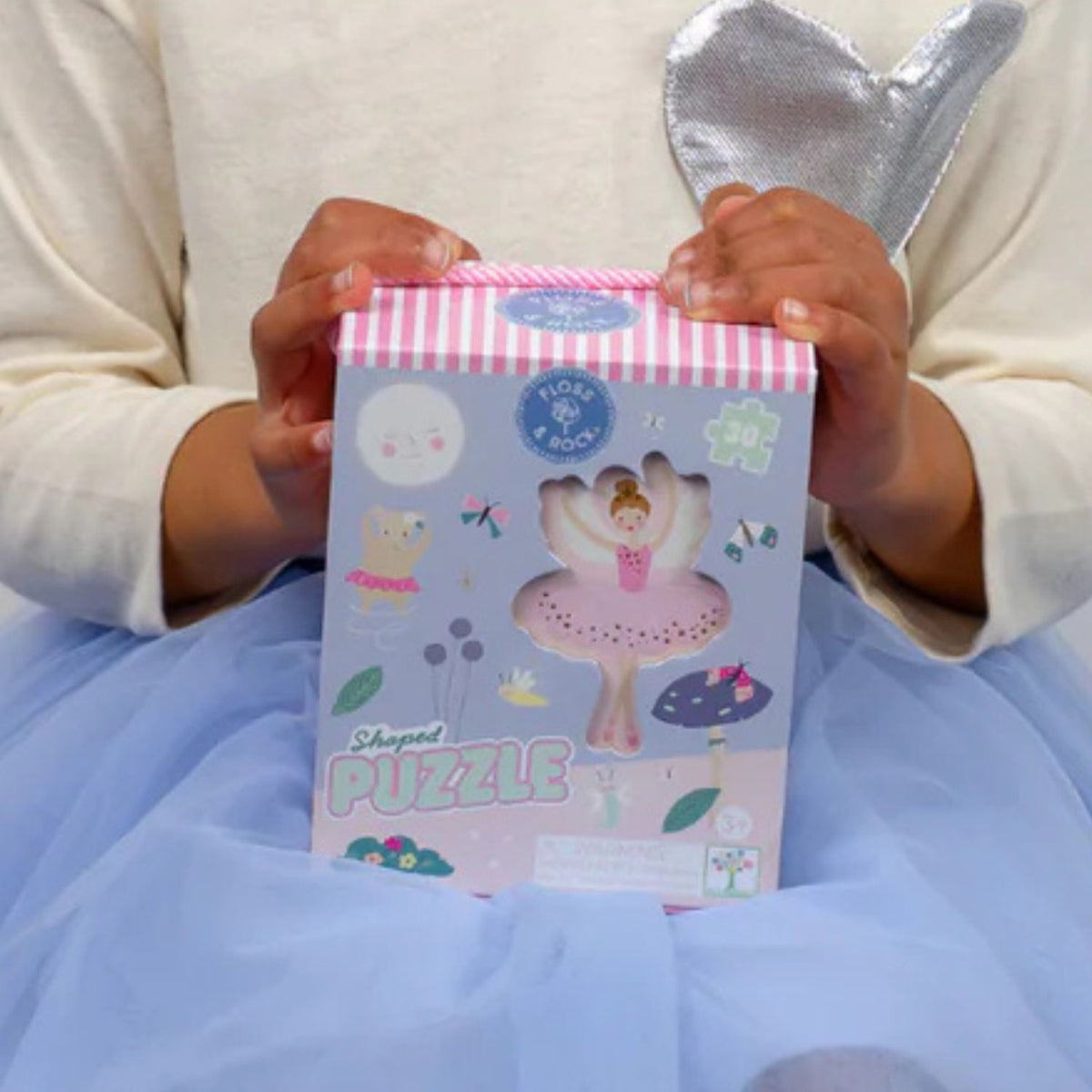 A close-up of a child’s hand holding a thick, durable puzzle piece, highlighting the high-quality print and kid-friendly size.