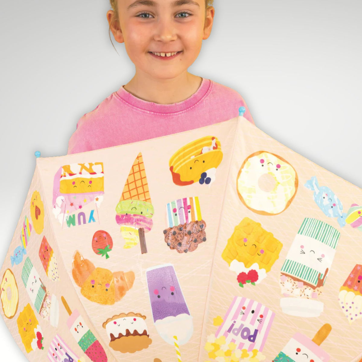 A child holding a colour changing umbrella that reveals hidden colours in the rain. Designed to make outdoor play more exciting for ages six and up.