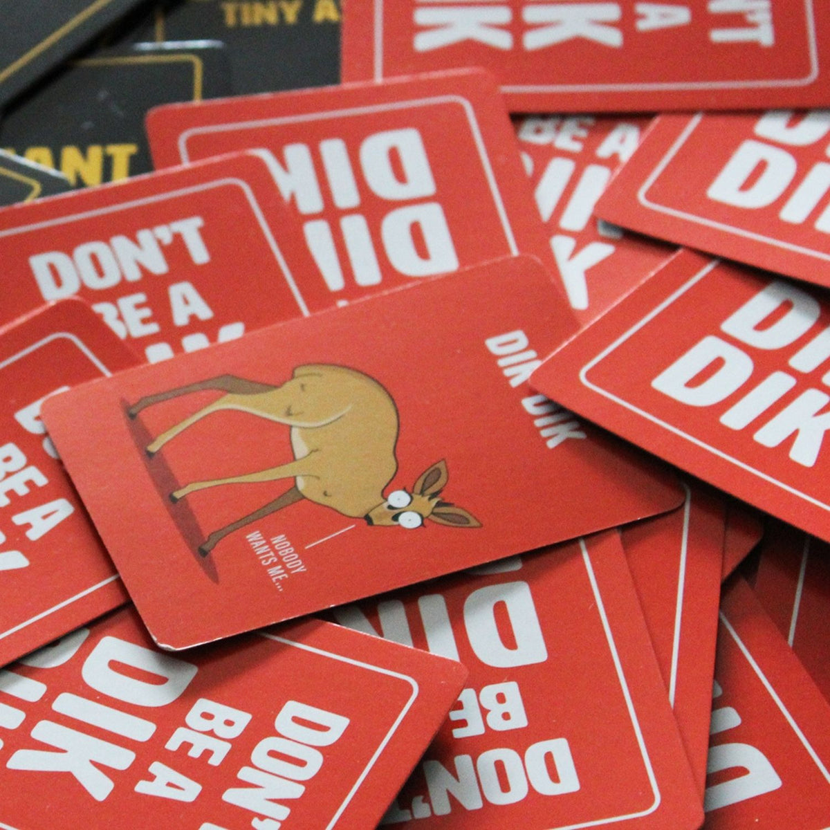 Red cards with a deer illustration and text on a pile