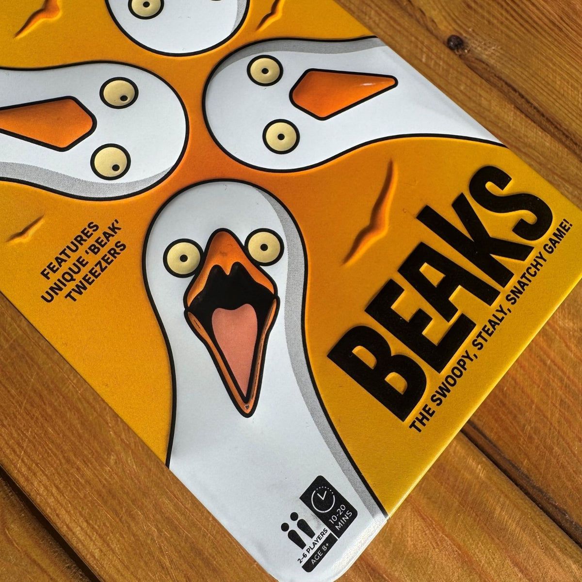 Beaks game tin with cartoon seagull design on a wooden surface