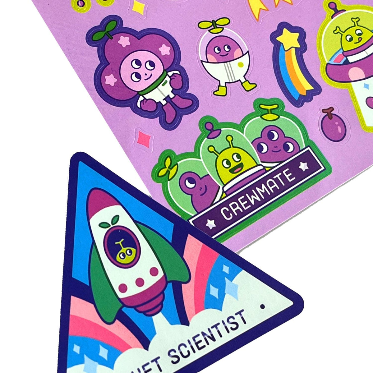 Colorful children's stickers with space-themed designs on a purple background