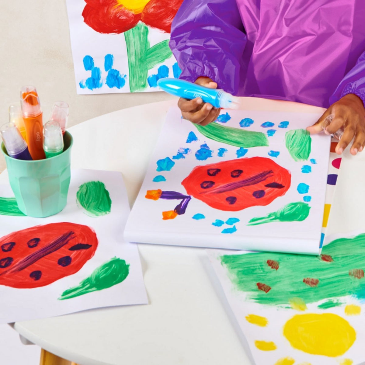 Children painting colorful pictures on paper with Easy Squeezy poster paint brushes.