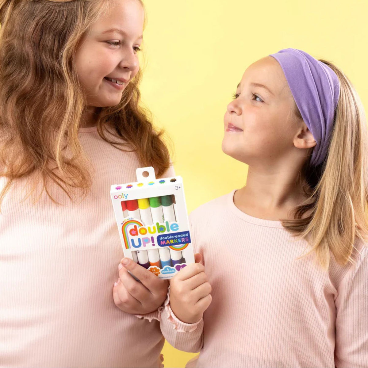 Two children holding a pack of Double Up! markers.