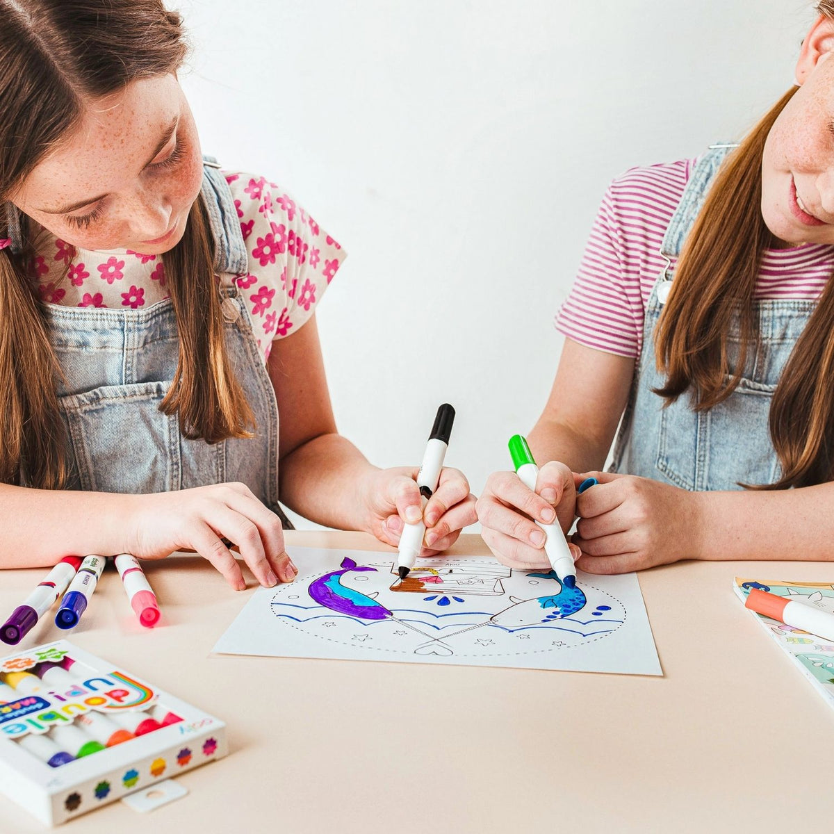 Two children sitting side-by-side sharing the set of Double Up Markers