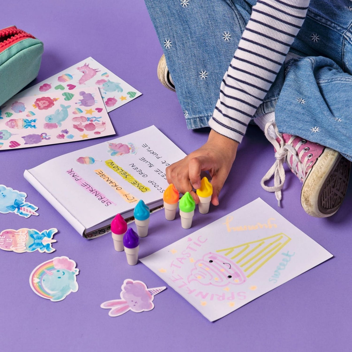 A hand using the yellow "strawberry" ice cream scoop highlighter to mark text in a planner, showing the broad neon stroke and high-visibility ink.