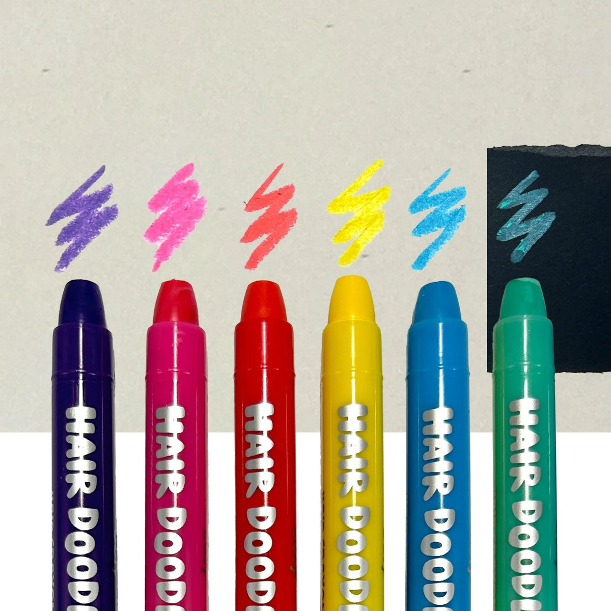 Set of colorful hair coloring markers with color samples on a light background