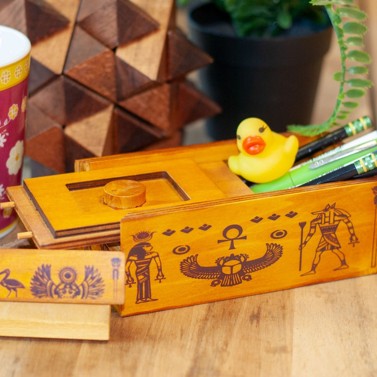 A wooden Pharaoh’s Tomb puzzle box featuring Egyptian hieroglyphic engravings and a multi-toned wood finish for ages eight and up.