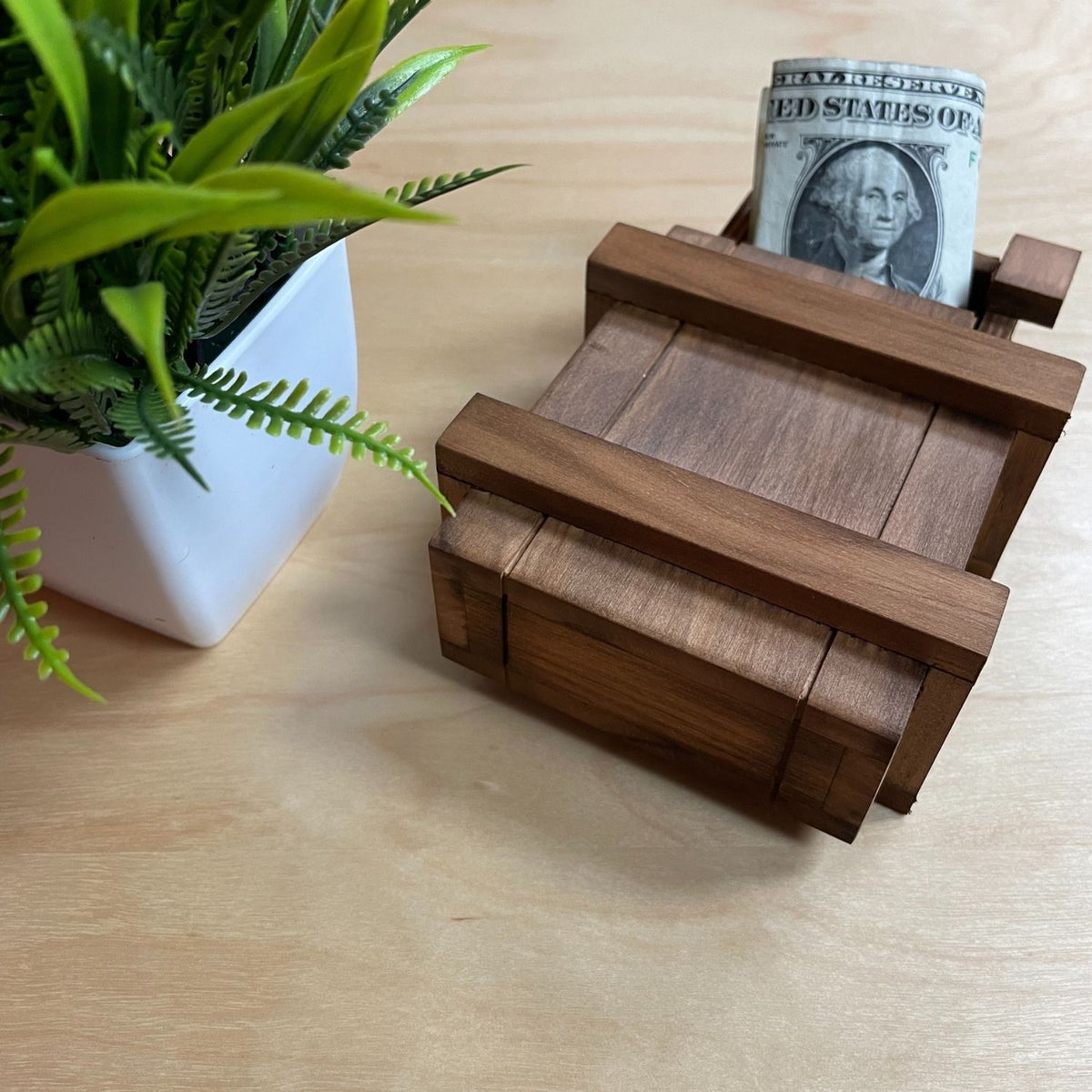 A close-up of the Sorcerer’s Box with the lid partially open, showing a gift card tucked inside the secret hidden compartment. A fun and interactive historical gift.