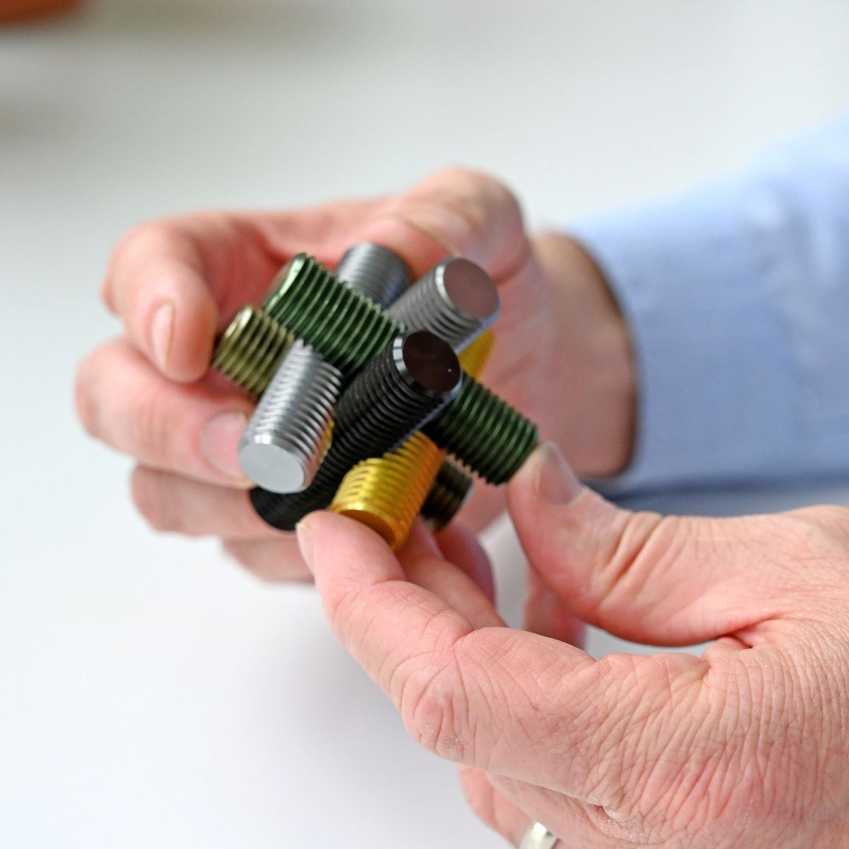 A close-up of hands manipulating the heavy metal bolts to slide and untangle the interlocking pieces of the Ancient Rome-themed puzzle.