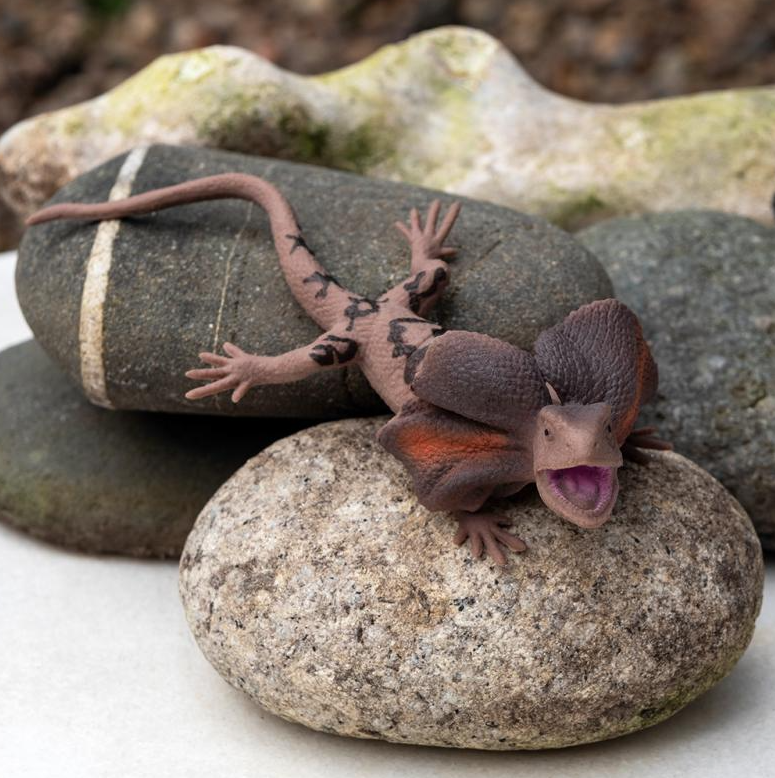 Toy lizard on a rock with a natural background