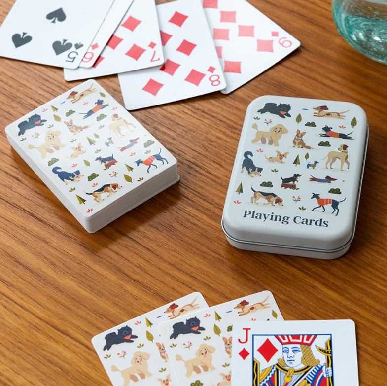 Playing cards with dog illustrations on a wooden surface